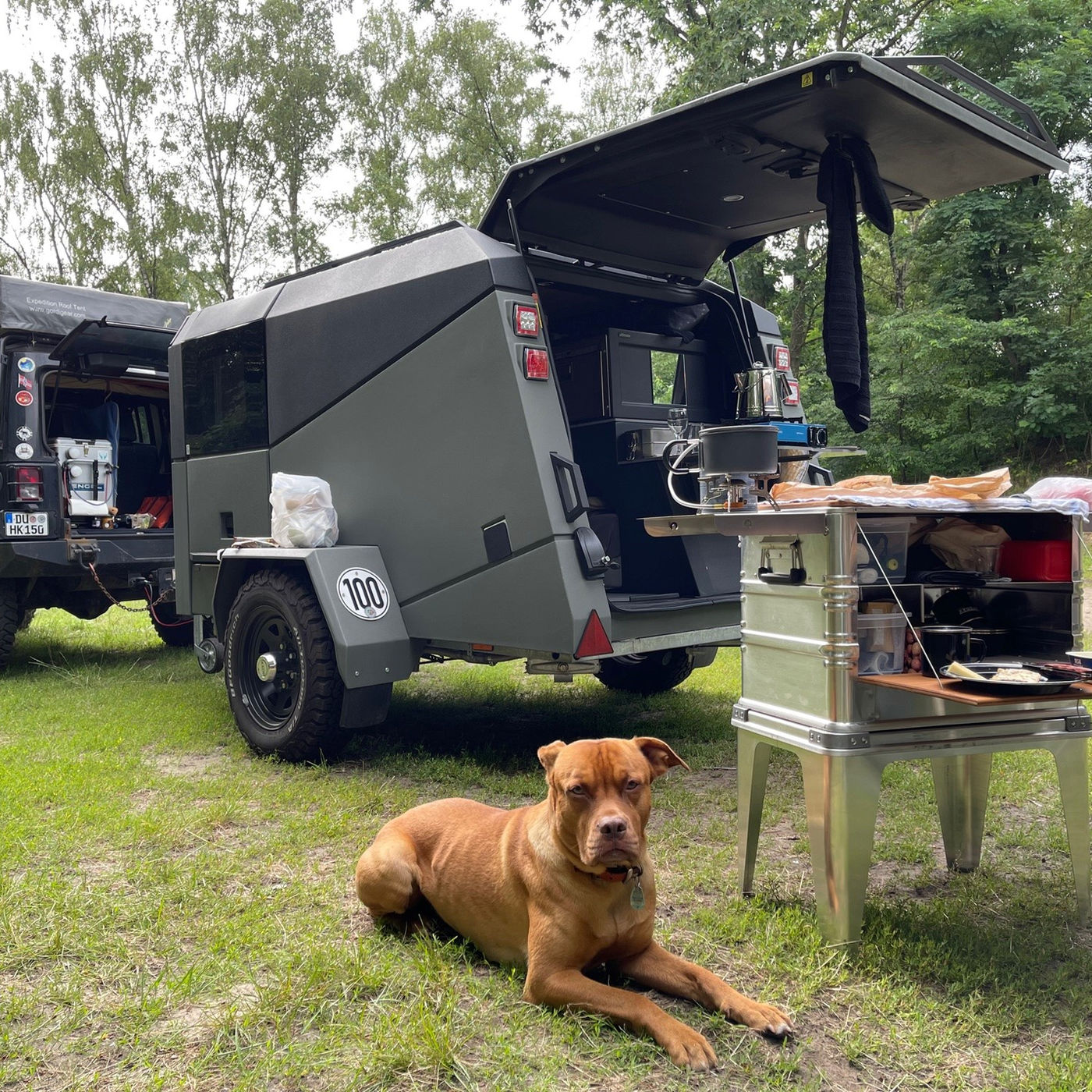 DOCK kitchen beside an off-road trailer with a dog on guard, Germany